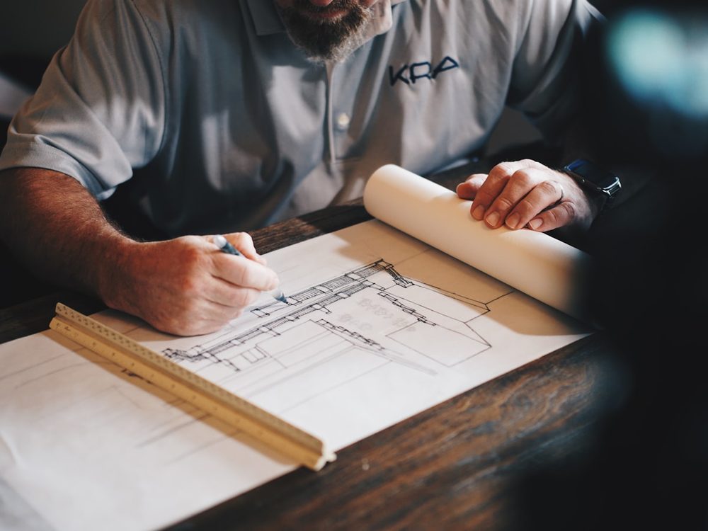 Profissional analisando a planta e a simulação de um financiamento de construção